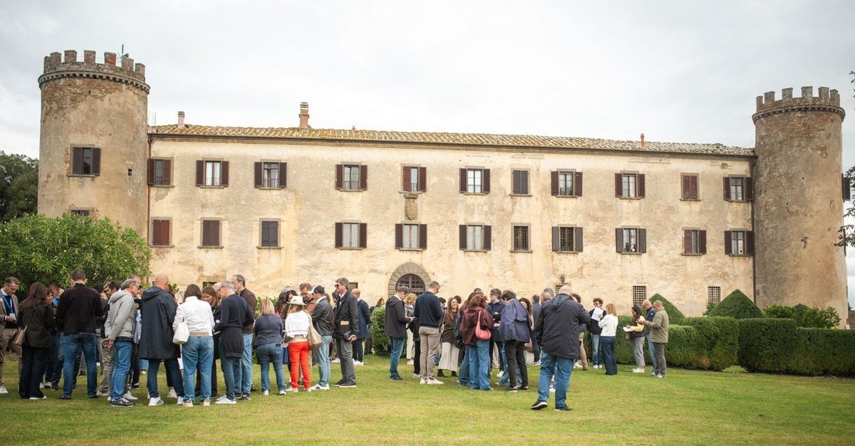Executives gathered on the lawn in front of the Castle of Calcione in Tuscany