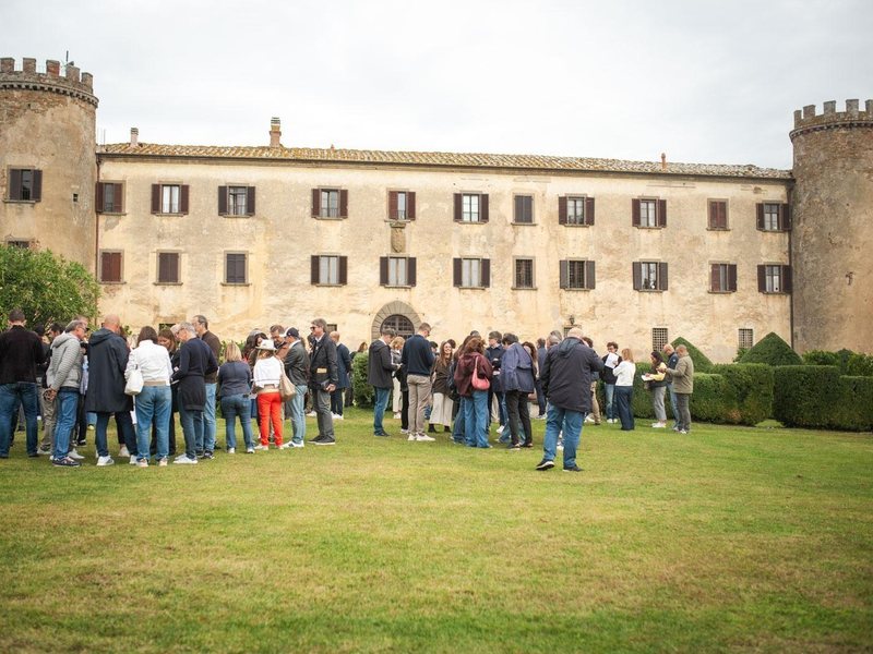 Executives gathered on the lawn in front of the Castle of Calcione in Tuscany